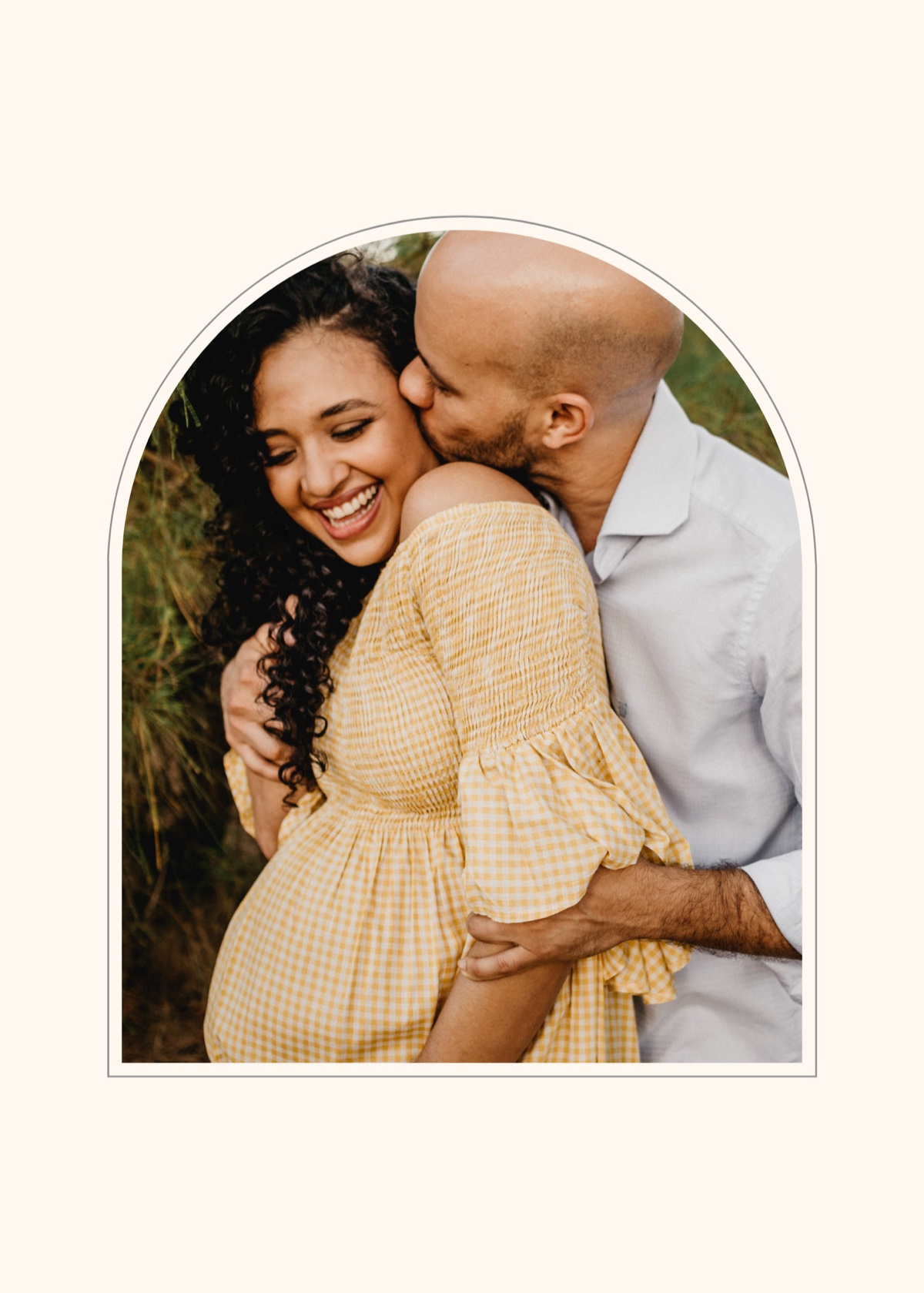Partner kissing a smiling pregnant woman on the cheek